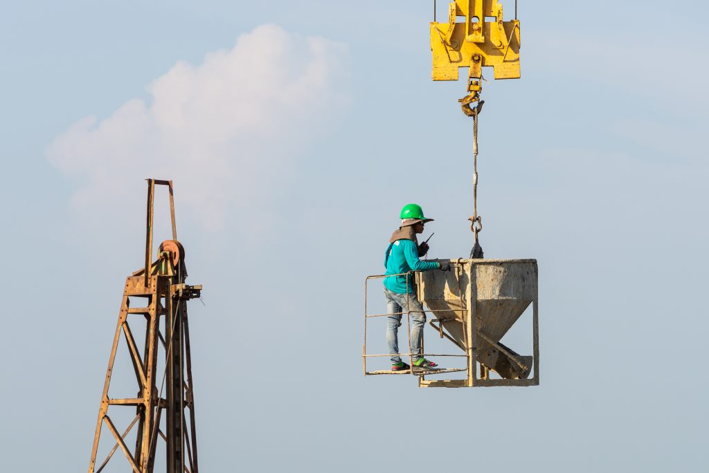 Trabajadores en obra con grua y estructura