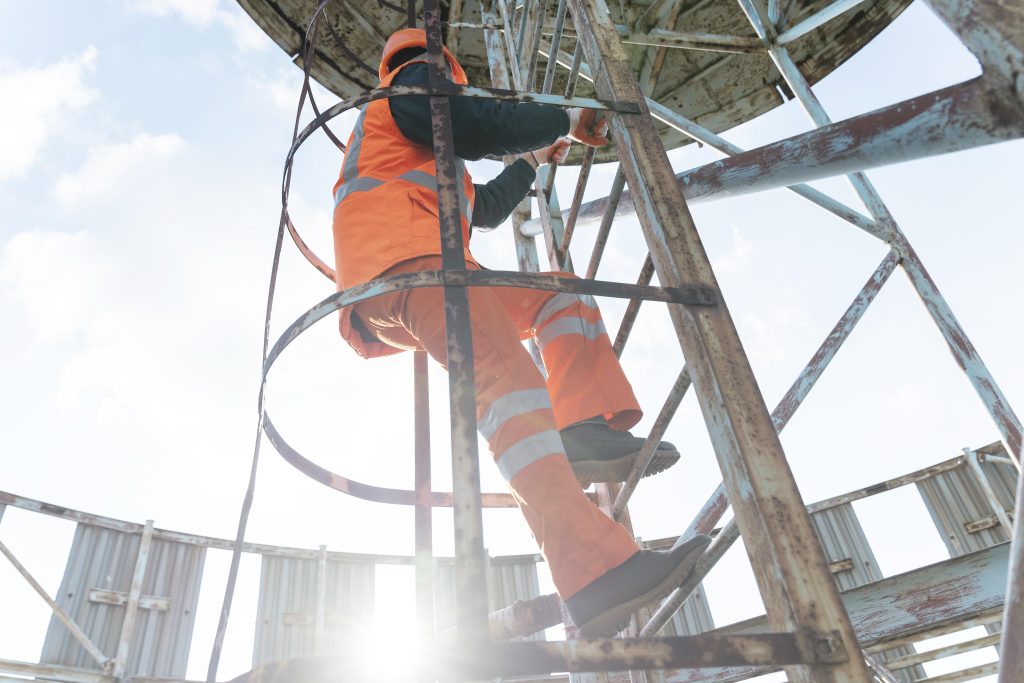 Trabajador con equipo de seguridad en escalera