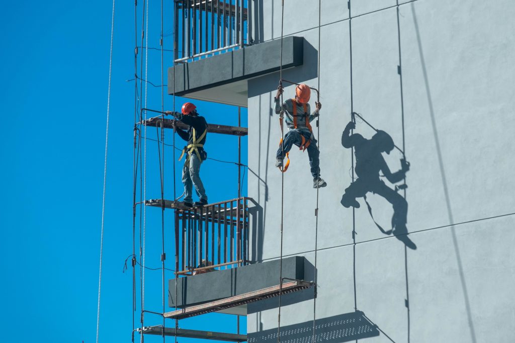 Operarios trabajando en andamio con medidas de seguridad
